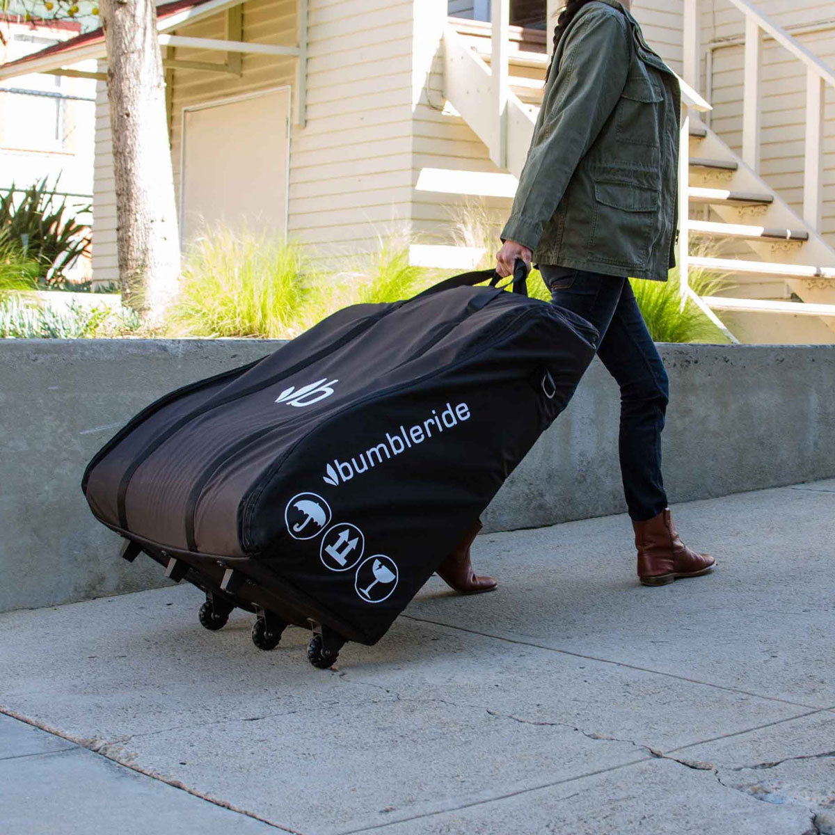 Woman pulling stroller in Bumbleride Travel Bag - Indie Twin - Black