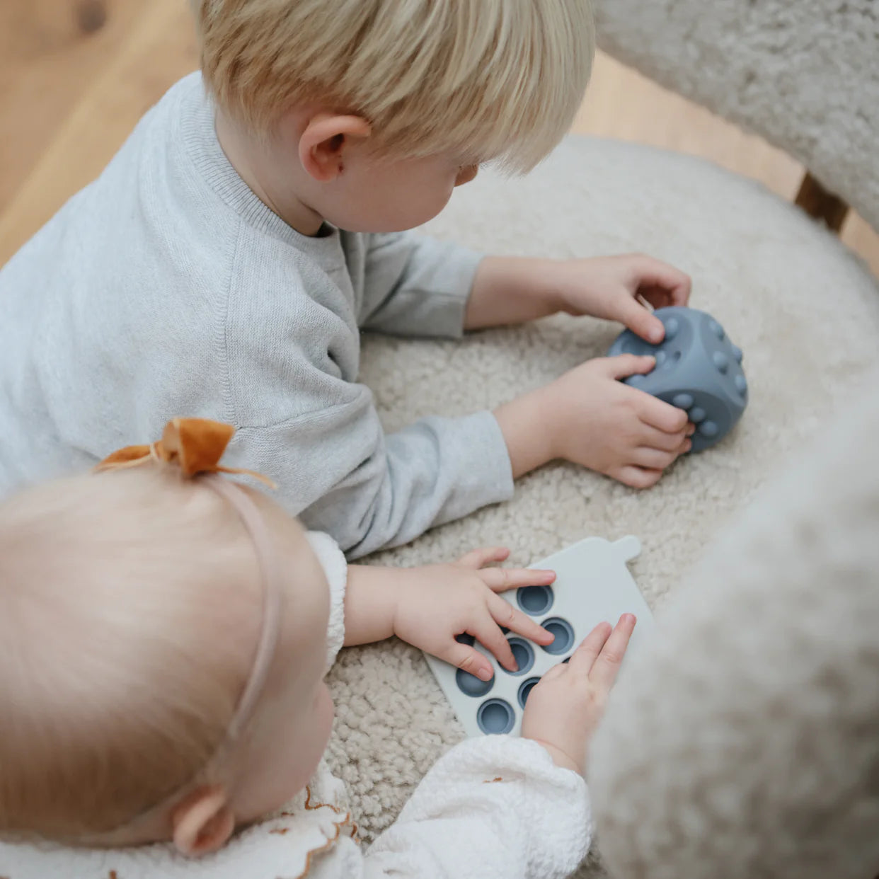Toddler playing with Mushie Dice Press Toy 2-Pack - Tradewinds