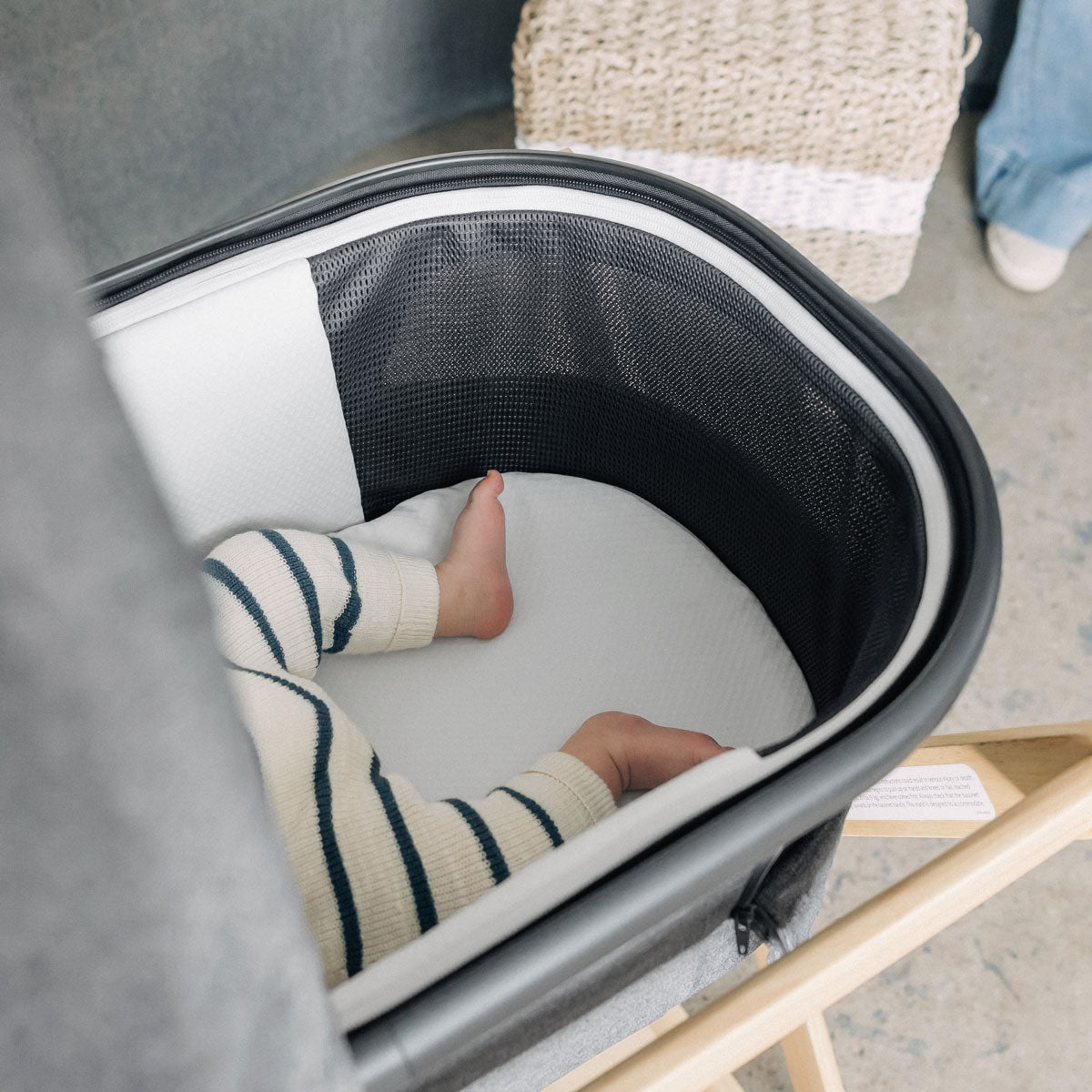 Baby lying in bassinet on top of UPPAbaby New Bassinet Mattress Cover - White