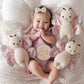 Baby smiles while laying next to Cuddle and Kind Baby Butterfly - Lavender