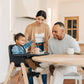 Parents smiling at child sitting in UPPAbaby CIRO High Chair - JAKE (Charcoal)