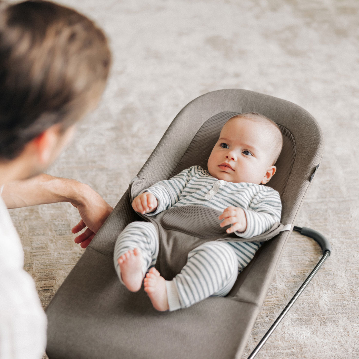 Dad looks at baby sitting in UPPAbaby MIRA 2-in-1 Bouncer and Seat - WELLS (Dark Taupe Melange)