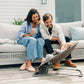 Mom and dad relax on patio while baby sits in UPPAbaby MIRA 2-in-1 Bouncer and Seat - WELLS (Dark Taupe Melange)