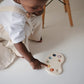Little boy plays with Mushie Paint Palette Press Toy