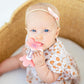 Baby girl chews on Ryan and Rose Flower Teether Rattle Toy - Shortcake