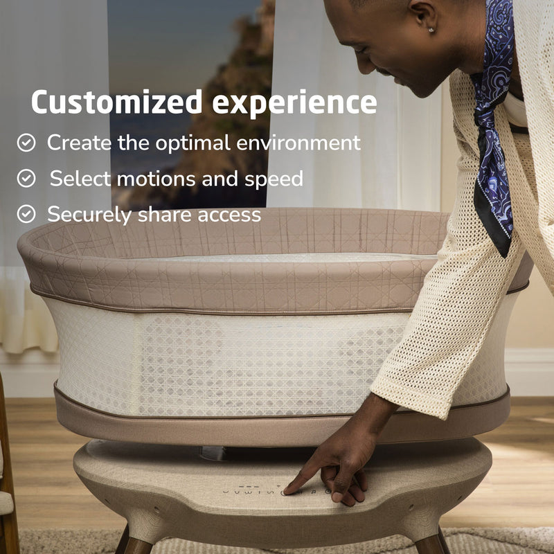 Dad adjusts settings on Maxi-Cosi Starling Smart Bassinet - Natural Heritage