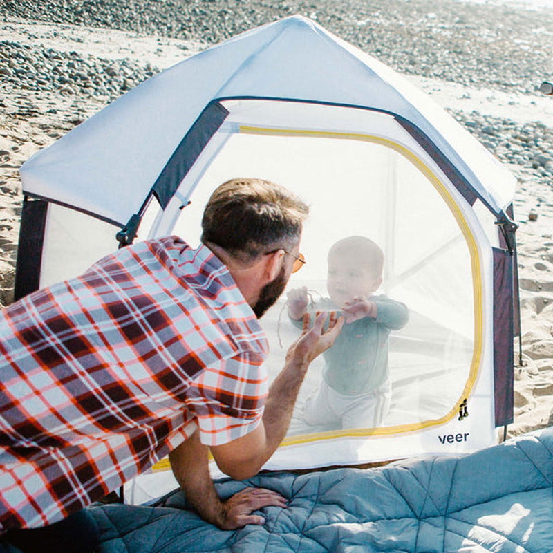Dad looks at baby inside playard of Veer Basecamp Bundle - Basecamp / Air Pad / Adventure Tote - White / Gray