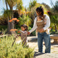 Mom looks at flowers with daughter while carrying baby in Nuna CUDL Luxe Carrier - Canyon