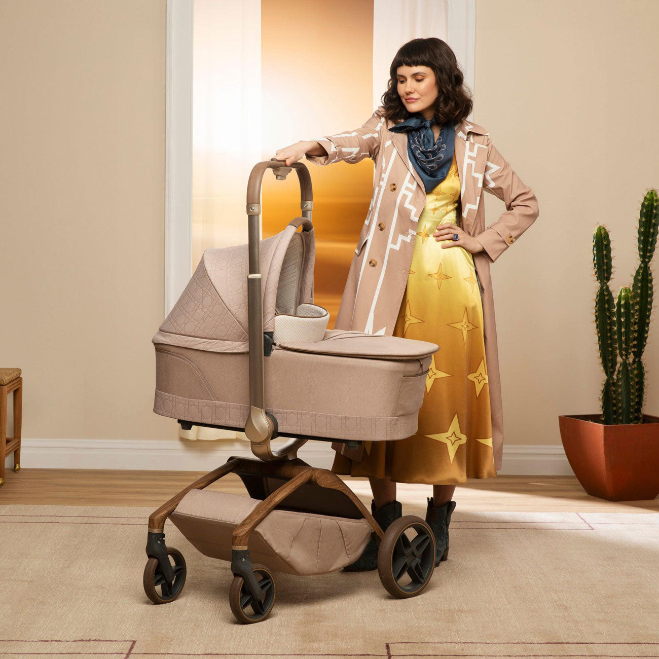 Mom holds handlebar of stroller with attached Maxi-Cosi Carriage Accessory - Natural Heritage