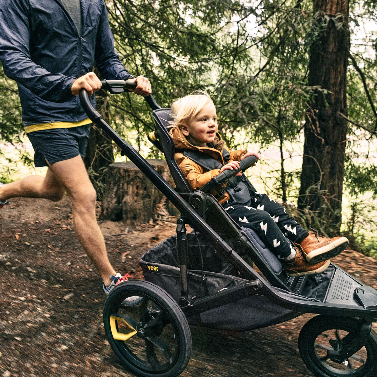 Man pushes child in Veer Switch&Jog Luxe Bundle - &Jog Jogging Frame / Switchback Seat Luxe - Gray Granite