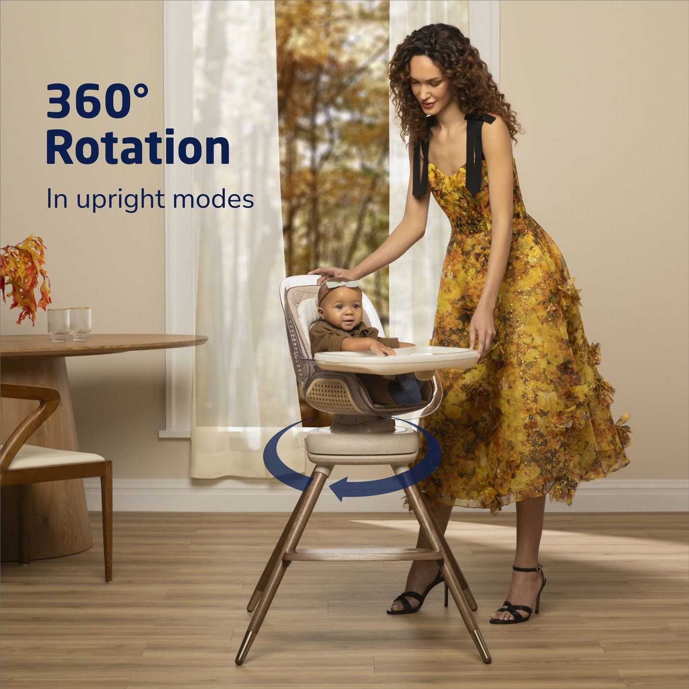 Mom rotates Maxi-Cosi Kiskadee 360 Rotating Highchair - Natural Heritage while baby girl sits in it