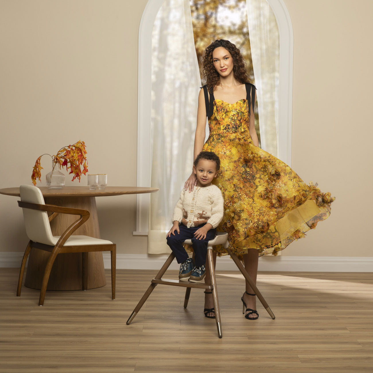 Mom stands next to child sitting in Maxi-Cosi Kiskadee 360 Rotating Highchair - Natural Heritage