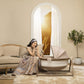 Woman sits on couch and looks into Maxi-Cosi Sibia Bassinet - Natural Heritage