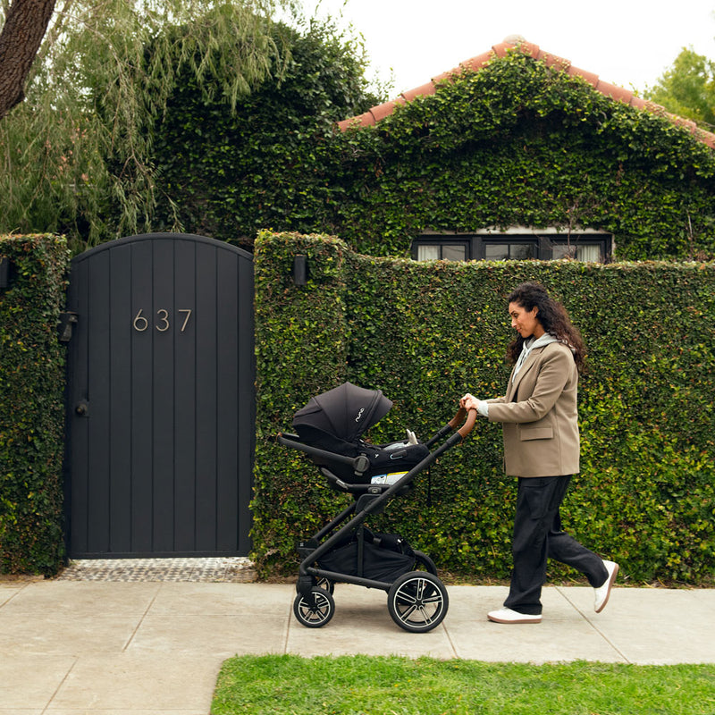 Mom pushes baby in Nuna MIXX Next Stroller and PIPA Aire RX Car Seat Travel System - Caviar