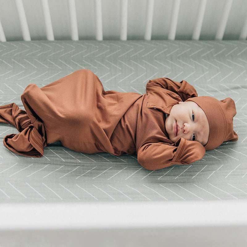 Baby lying on Mebie Baby Muslin Crib Sheet- Desert Sage