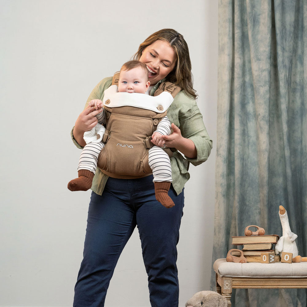 Mom carries baby forward facing in Nuna CUDL Luxe Carrier - Canyon