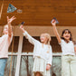 Children play with paper airplanes they made from OOLY D.I.Y. Paper Air Planes Activity Kit - Set of 24