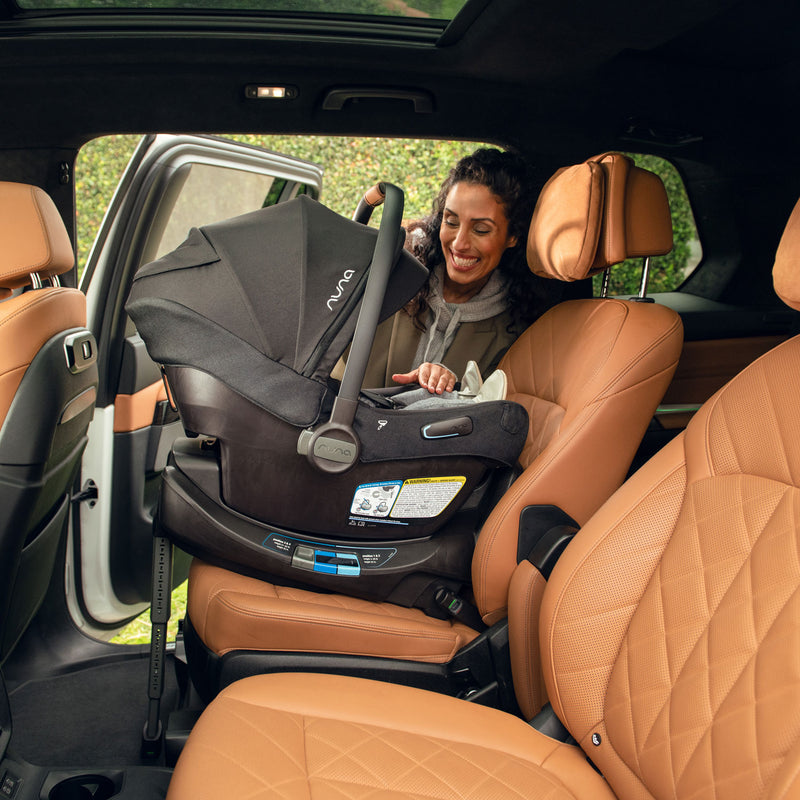 Mom placing baby into vehicle in car seat of Nuna MIXX Next Stroller and PIPA Aire RX Car Seat Travel System - Caviar