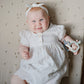 Baby smiles while holding Mushie Key Toy - Original
