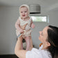 Woman holds up baby holding Mushie Key Toy - Original