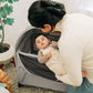 Mom lifts baby out of REMI playard with UPPAbaby REMI Playard Canopy attached