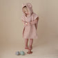 Child plays with bath toys while wearing Mushie Bear Poncho Towel - Blush