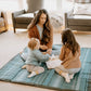 mom and kids sit on Little Unicorn Outdoor Blanket - 5x10