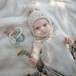 Baby lying next to Mushie Key Toy - Original