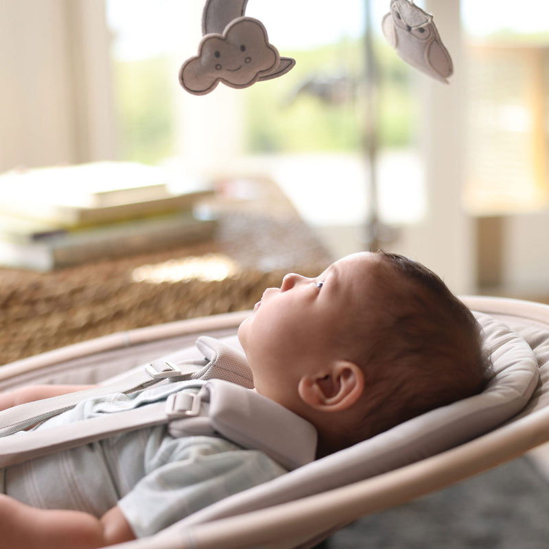 Baby looks up at mobile attached to Maxi-Cosi Cassia Swing - Classic Oat