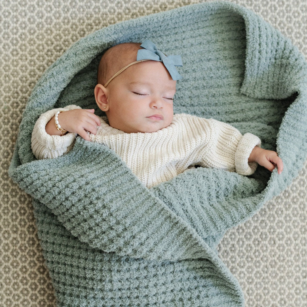Sleeping baby wrapped in Saranoni Receiving Waffle Knit Blanket - Elm