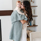 Mom holds baby girl wrapped in Saranoni Receiving Waffle Knit Blanket - Elm