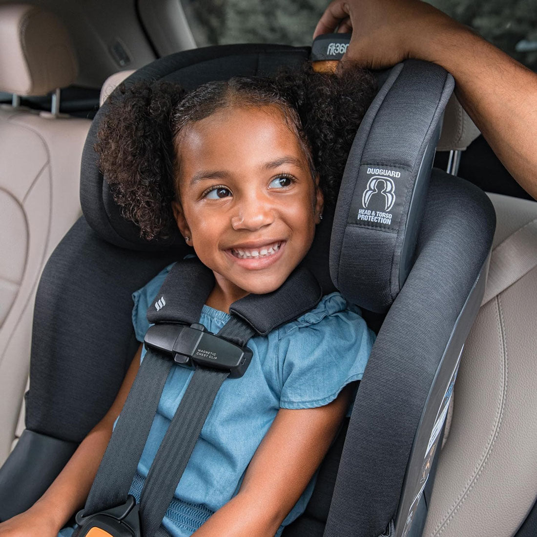 Parent adjusts headrest for little girl riding forward facing in Chicco Fit360 ClearTex Rotating Convertible Car Seat - Black