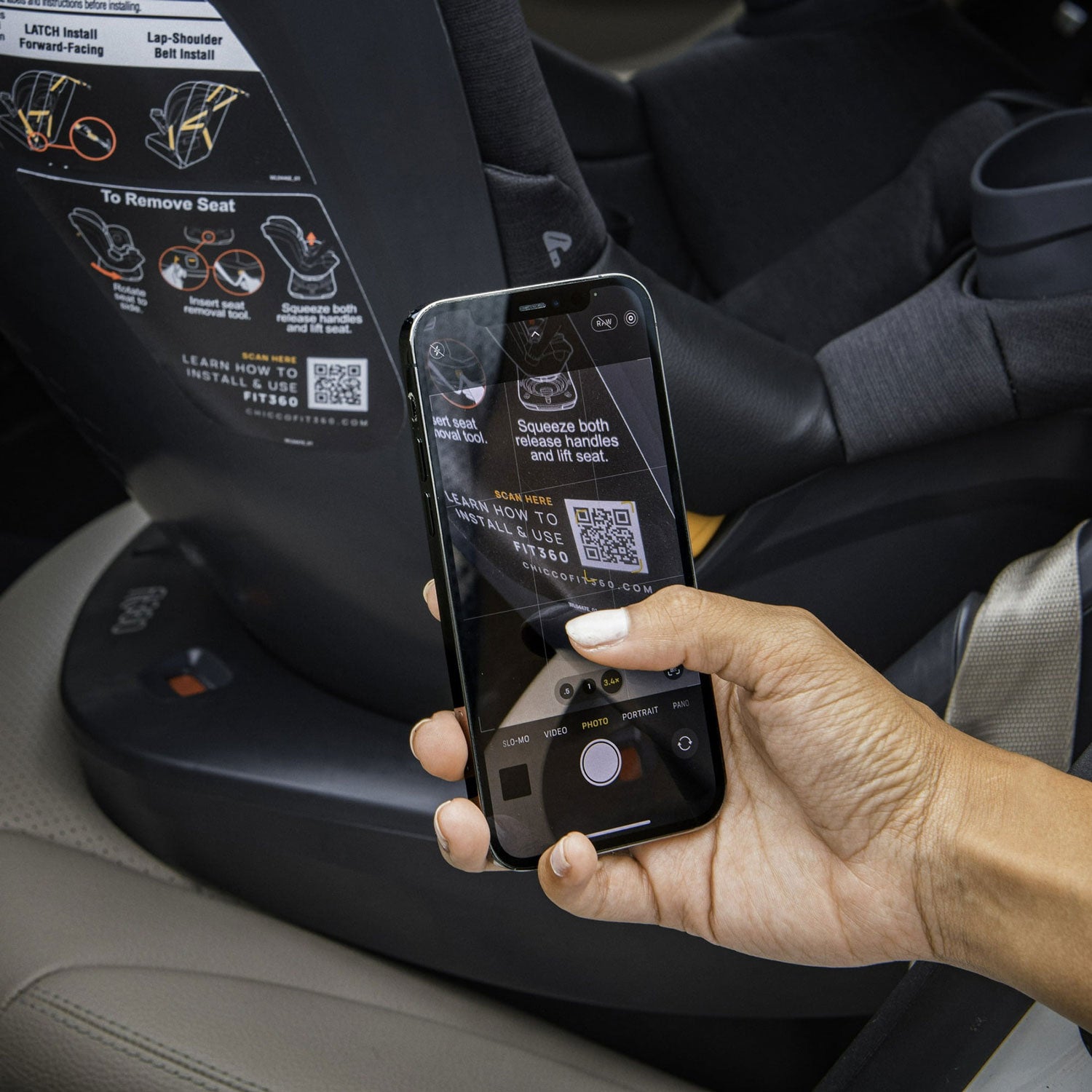 Parent scanning QR code on Chicco Fit360 ClearTex Rotating Convertible Car Seat - Black