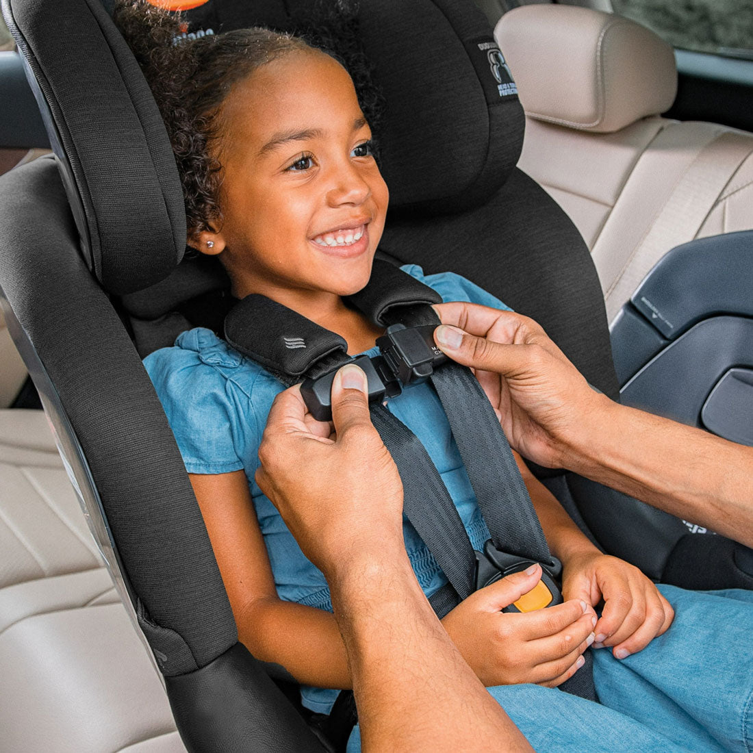 Parent buckles girl into Chicco Fit360 ClearTex Rotating Convertible Car Seat - Black