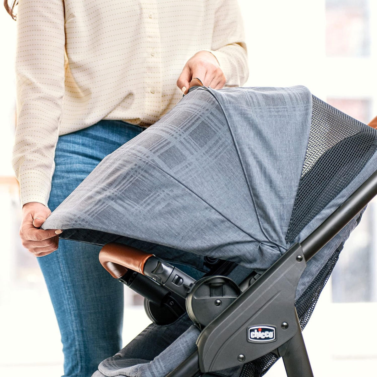 Woman extends canopy of Chicco Corso LE Modular Travel System - Hampton