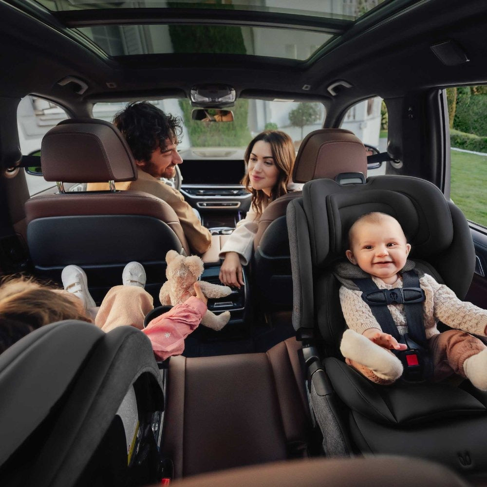 Two kids in backseat of car sitting in Romer Veni Convertible Car Seat - Peppercorn