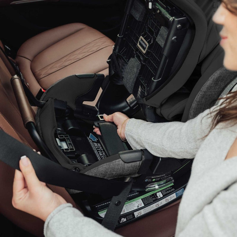 Woman installing Romer Veni Convertible Car Seat - Peppercorn in vehicle