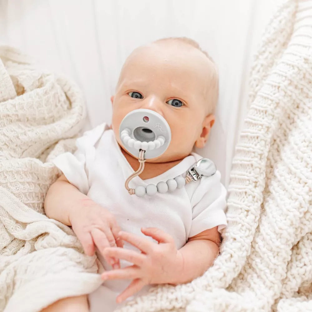 Baby sucks on Ryan and Rose Flat Cutie PAT Pacifier 2 Pack - Grey / White