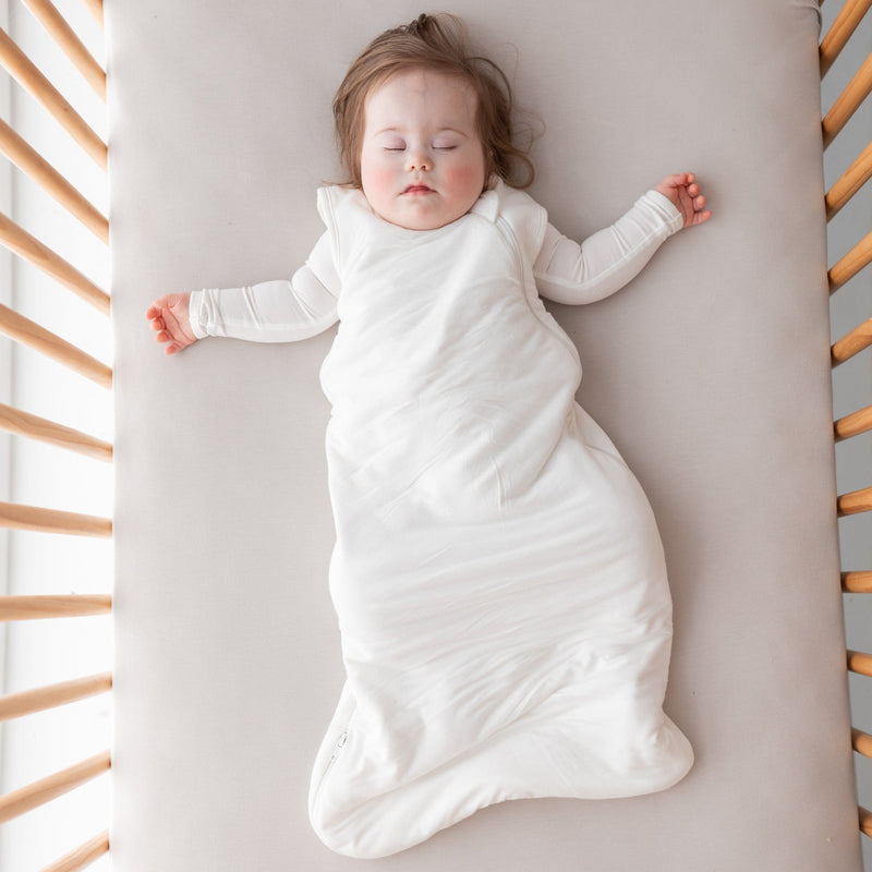 Baby girl sleeps in crib in Kyte BABY Sleep Bag - Cloud - 1.0 Tog