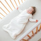 Baby girl sleeps in crib in Kyte BABY Sleep Bag - Cloud - 1.0 Tog
