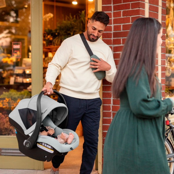 Dad carries baby in car seat of Maxi-Cosi Zelia2 Luxe+ 5-in-1 Travel System with Mico Luxe+ - Arctic Frost