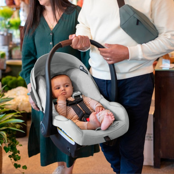 Dad carries baby in car seat of Maxi-Cosi Zelia2 Luxe+ 5-in-1 Travel System with Mico Luxe+ - Arctic Frost