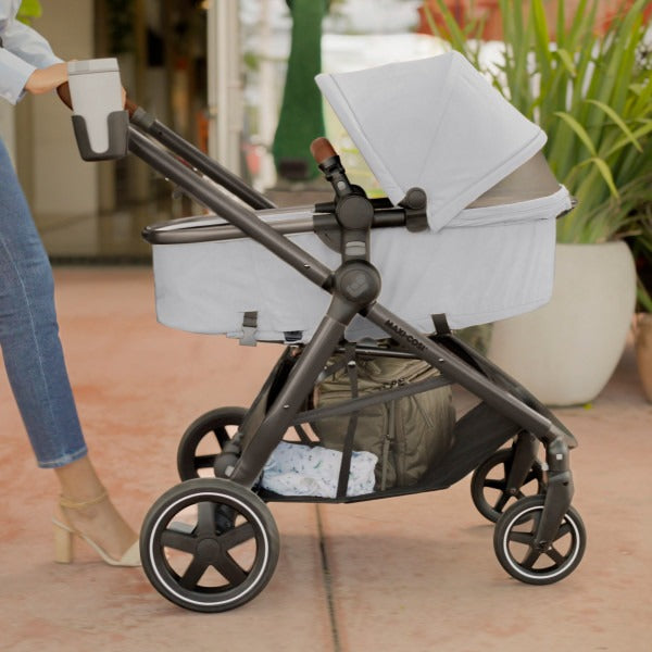 Mom pushes baby in bassinet mode of Maxi-Cosi Zelia2 Luxe+ 5-in-1 Travel System with Mico Luxe+ - Arctic Frost