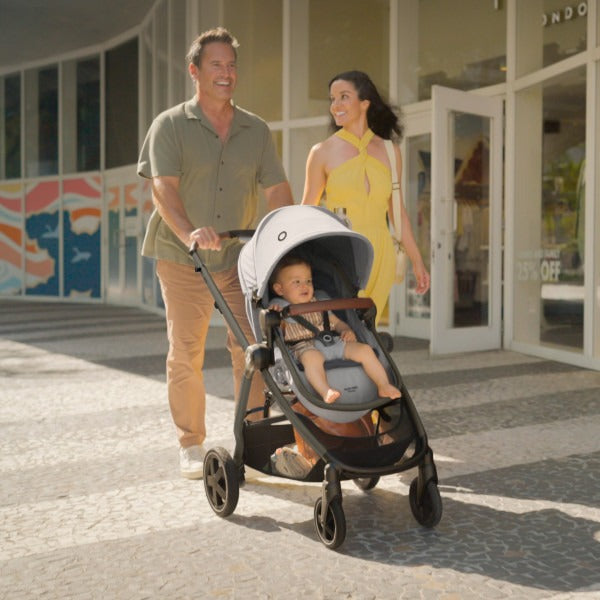 Mom and dad push baby in Maxi-Cosi Zelia2 Luxe+ 5-in-1 Travel System with Mico Luxe+ - Arctic Frost