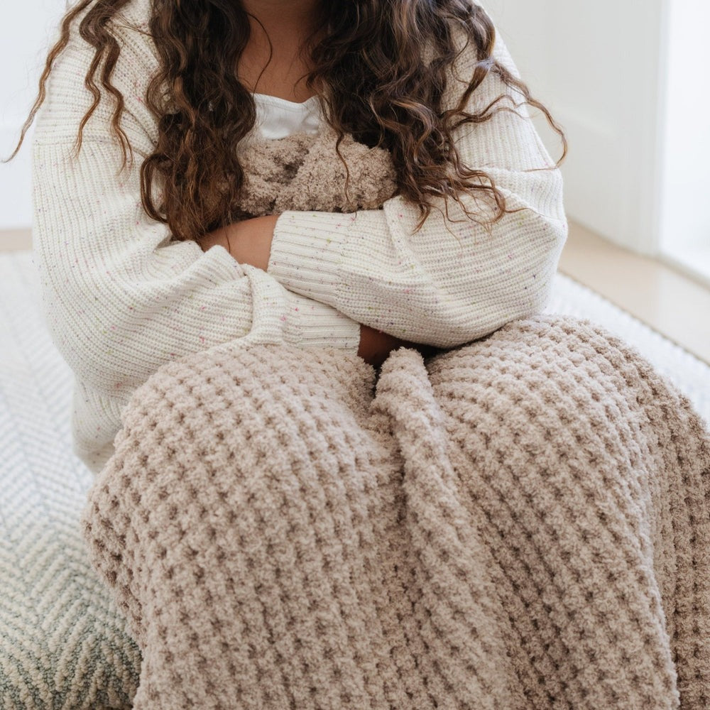 Little girl holds Saranoni Waffle Knit Toddler Blanket - Wheat