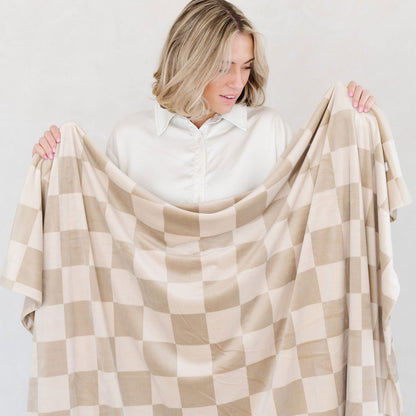 Woman holds up Saranoni Receiving Minky Stretch Blanket - Neutral Checkered