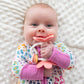 Baby girl chews on Ryan and Rose Flower Teether Rattle Toy - Shortcake