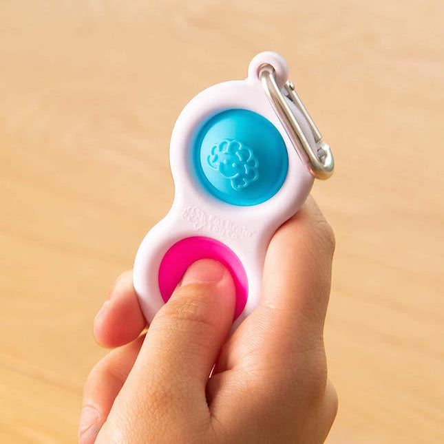 Hand pressing Fat Brain Toys Simpl Dimpl Clip - Bule / Pink