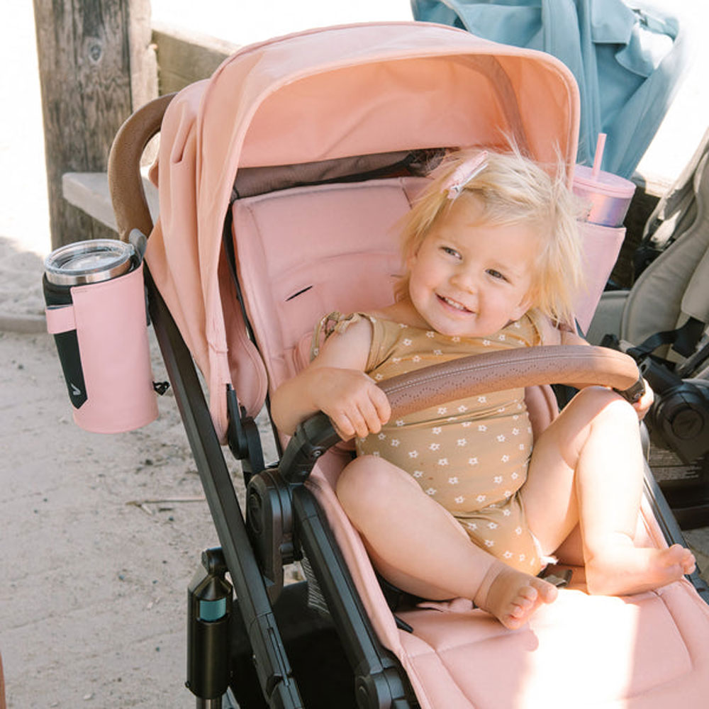 Baby sits in Veer Switch&Roll Leather Kit Luxe Bundle - &Roll Stroller Frame / Switchback Seat Luxe / Genuine Napa Leather Grips for Handle and Armbar - Saddle