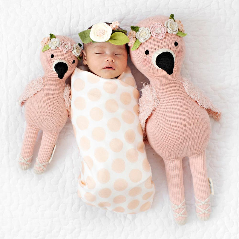 Newborn baby sleeping next to Cuddle and Kind Penelope the Flamingo